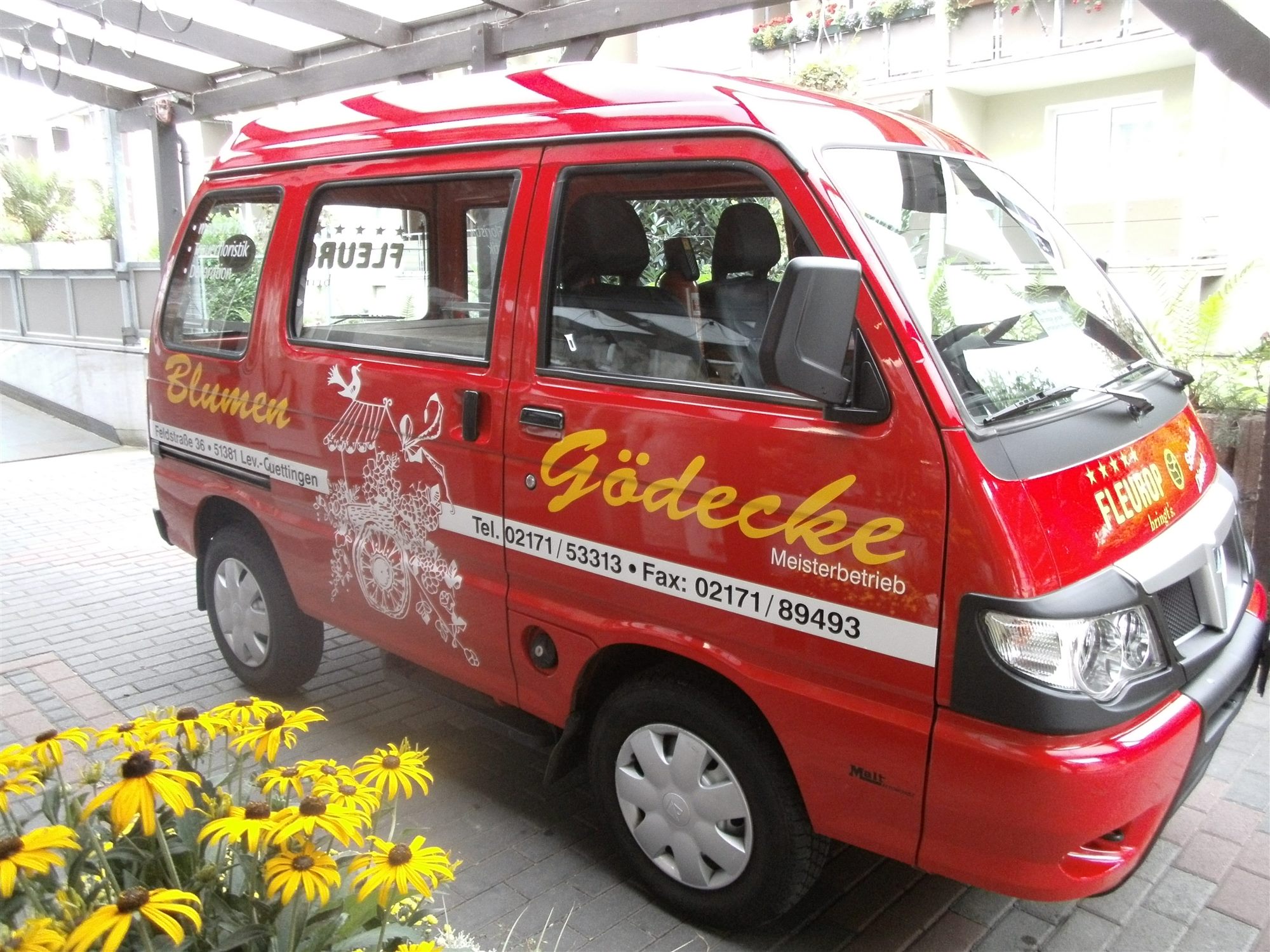Roter Lieferwagen von Blumen Gödecke vor dem Geschäft